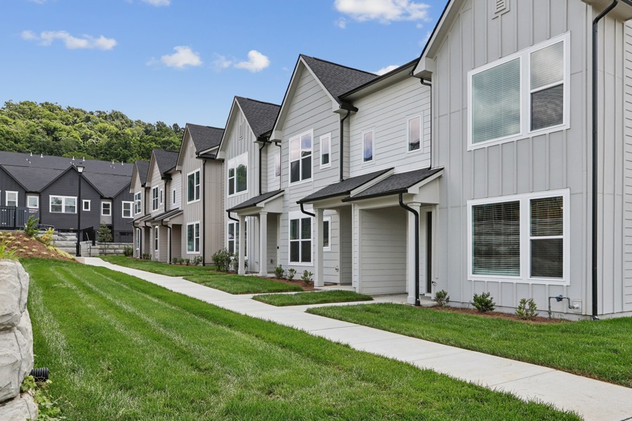 Modern townhome residences with private entrances, landscaped walkways, and contemporary architecture at HARMON West Meade in Nashville, Tennessee.
