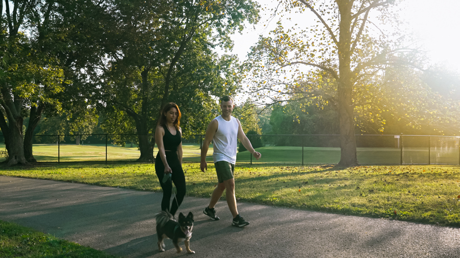 Residents walking a dog along a scenic trail in Percy Warner Park near HARMON West Meade in Nashville, Tennessee.